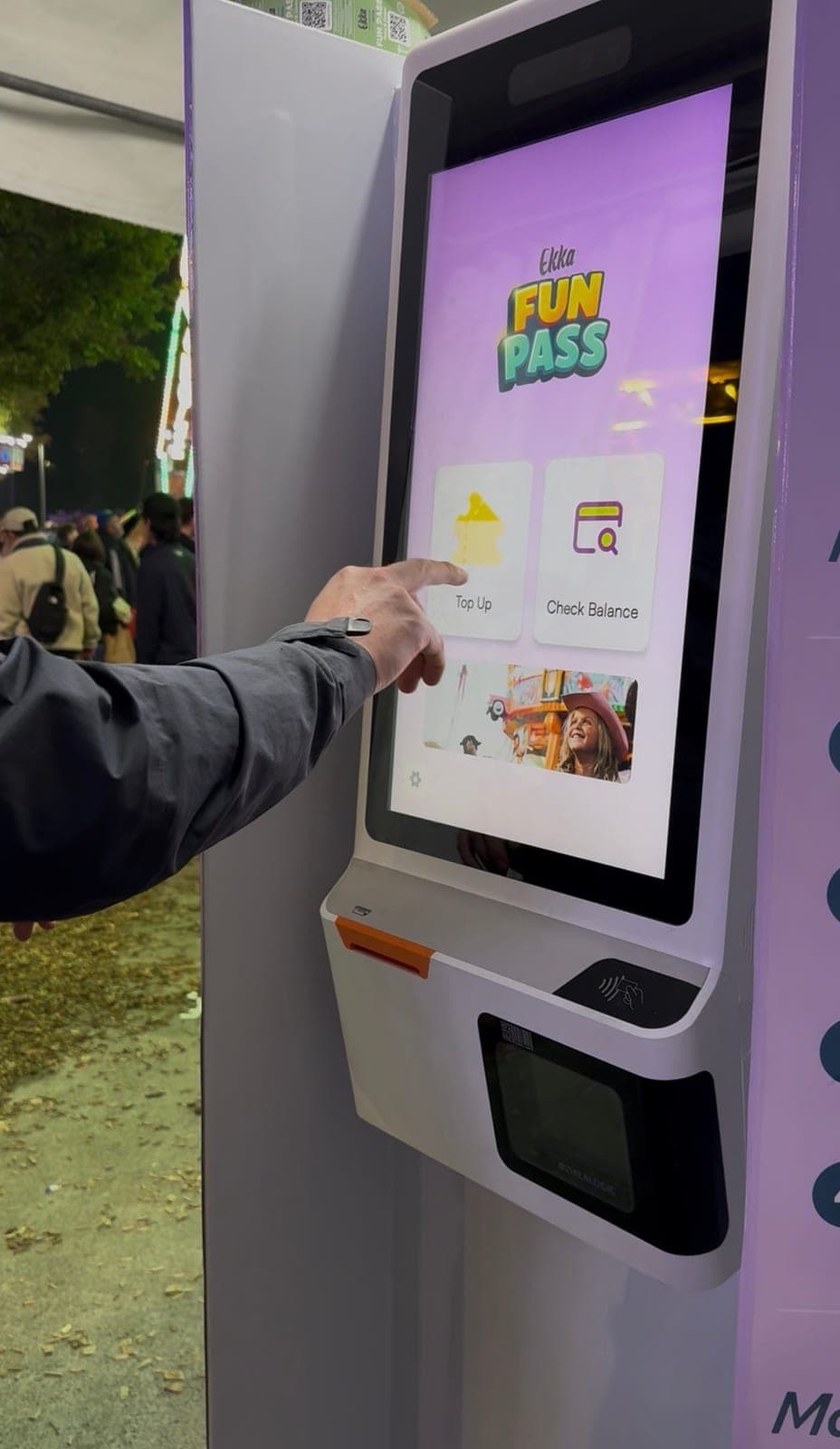 A visitor using a Ludo self-service top-up kiosk at Ekka